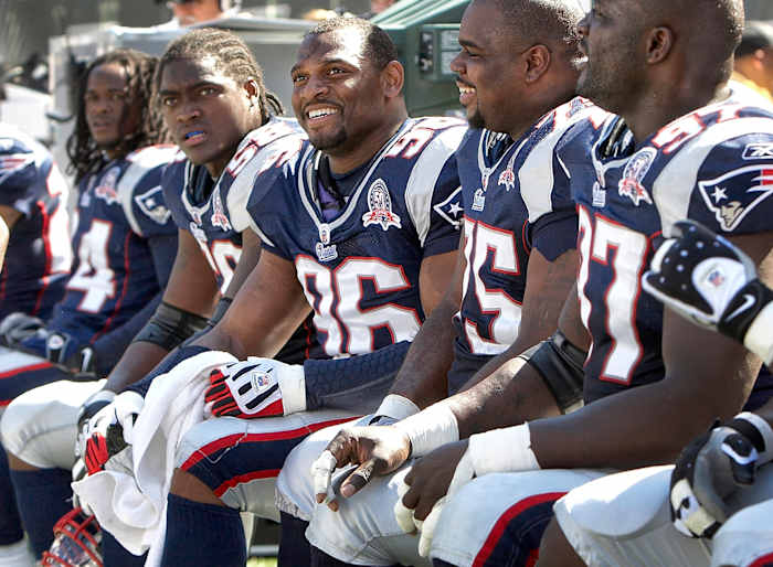 Adalius Thomas and Patriots defensive players on the bench during a game